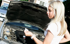 Woman checks the oil level on her car