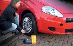 Woman inflating the tyres on her car