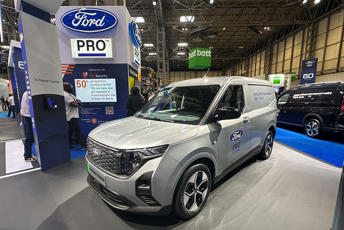 Ford electric van on display at CV Show exhibition hall with Pro branding signage.