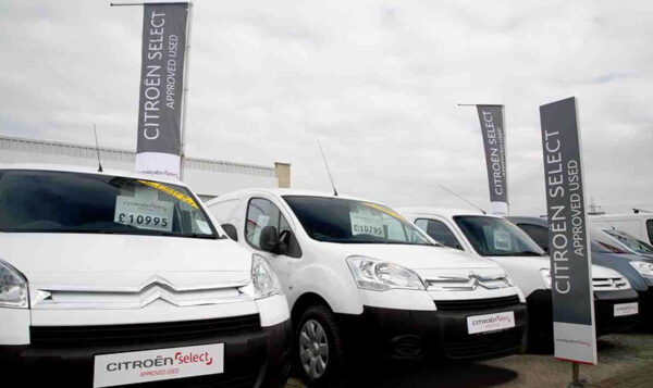 Citroën Select used van dealership forecourt displaying white vans with price boards and branded banners.