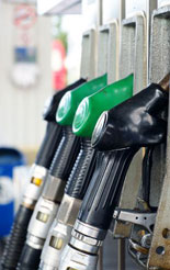Petrol and diesel pump nozzles at a service station forecourt.
