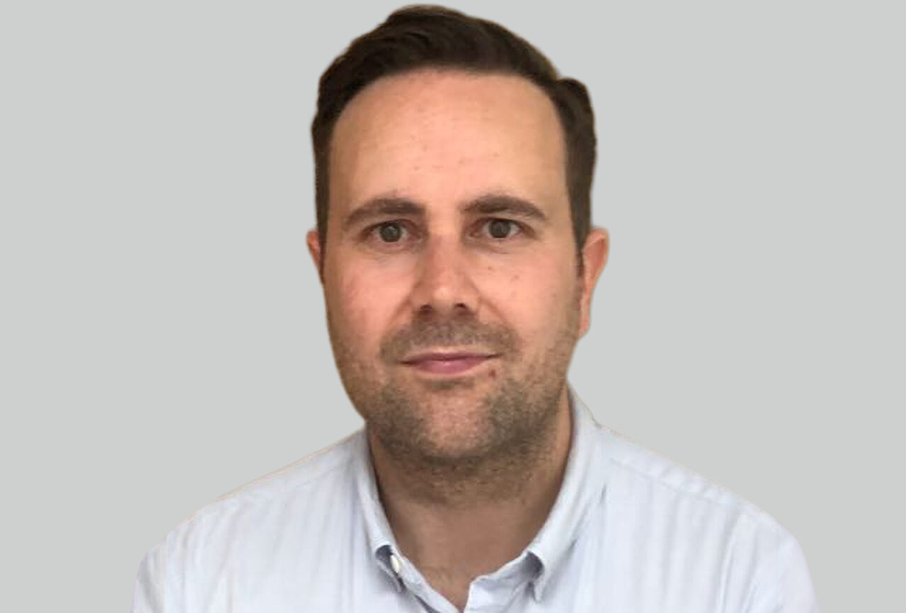 Adam Gooch, UK insurance director at Targa Telematics, headshot against grey background.
