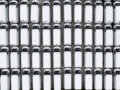 Full frame aerial view of new white vans parked together after manufacturing for import and export