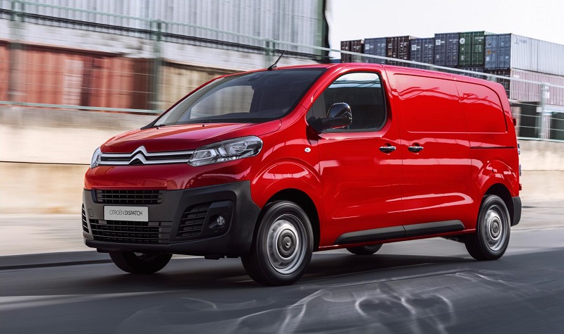 Red Citroën Dispatch van parked in industrial setting with shipping containers in background.