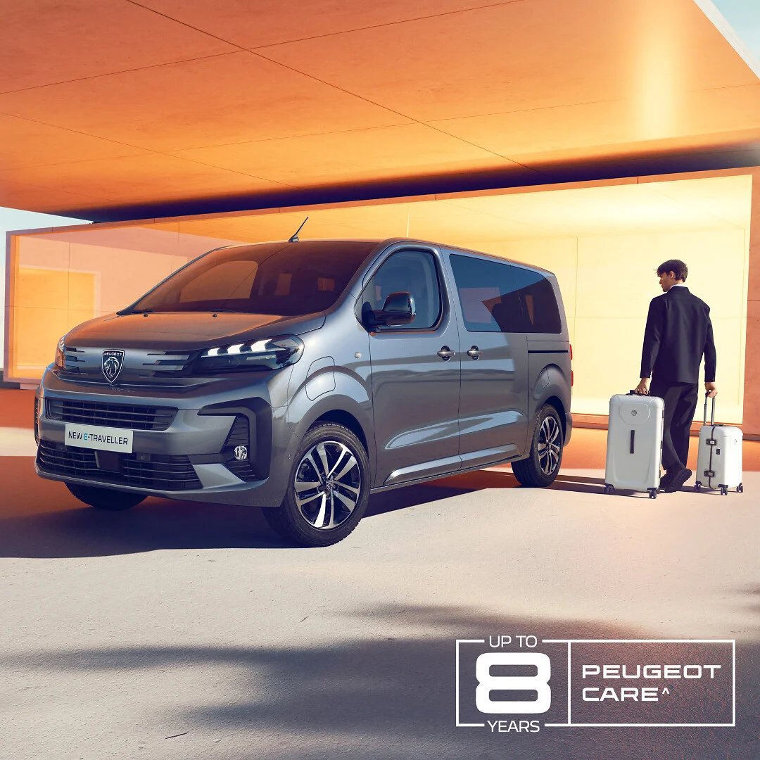 Peugeot electric van in modern showroom with man standing beside luggage, promoting eight-year PEUGEOT CARE warranty…