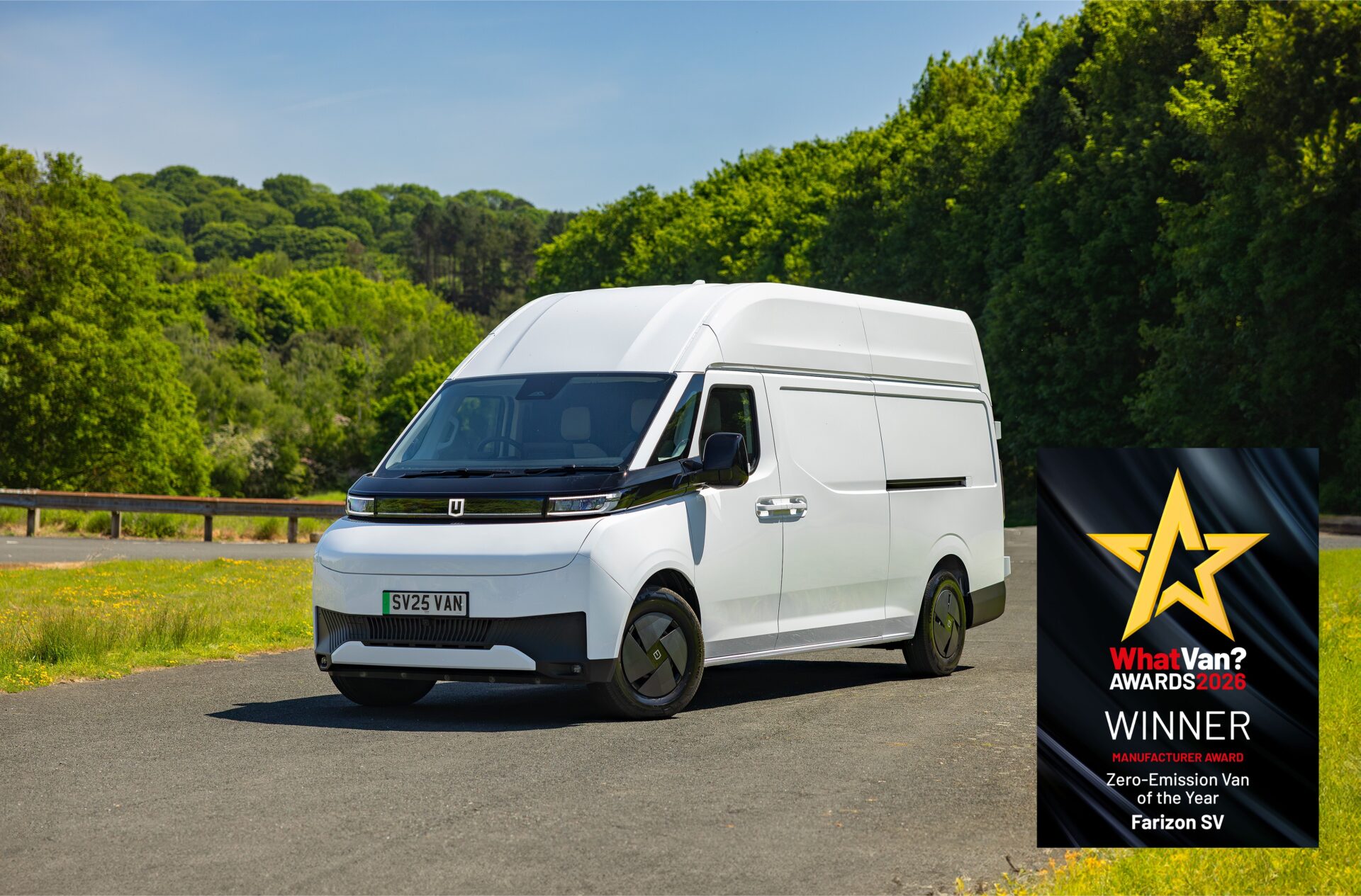 White Farizon SV electric van parked on country road with green fields and woodland behind, displaying What Van? Awards…