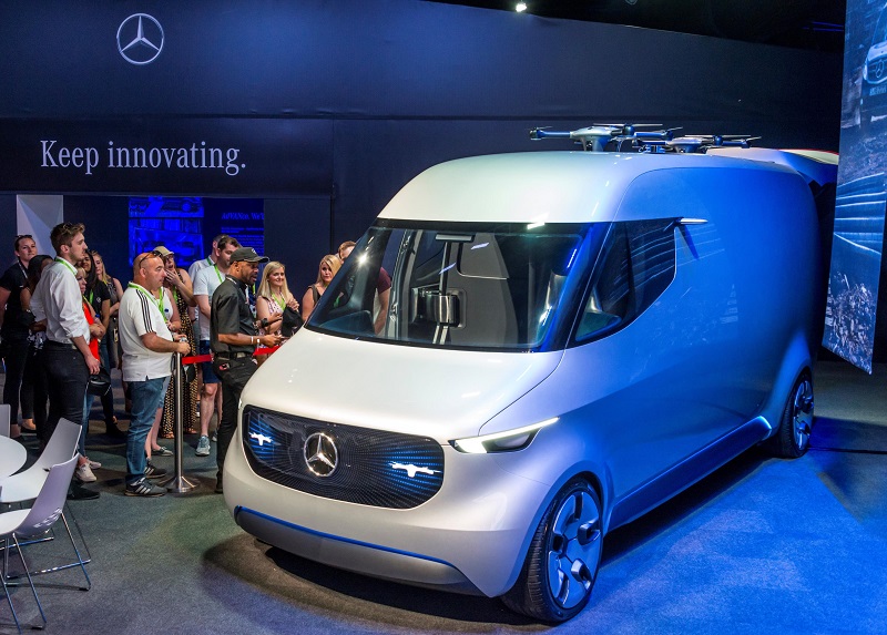 Mercedes-Benz electric van concept displayed at motor show with visitors gathered around it beneath "Keep innovating" sign.