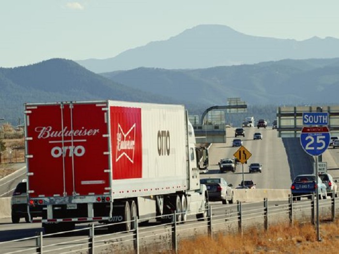Budweiser branded articulated lorry on multi-lane US highway with mountains in background and Interstate 25 sign visible.