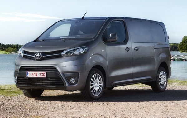 Silver Toyota Proace van parked on gravel beside water, front three-quarter view.