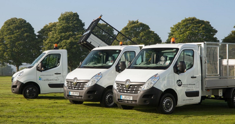 Three white Renault tipper vans parked on grass with trees behind, showing various body configurations including open and…