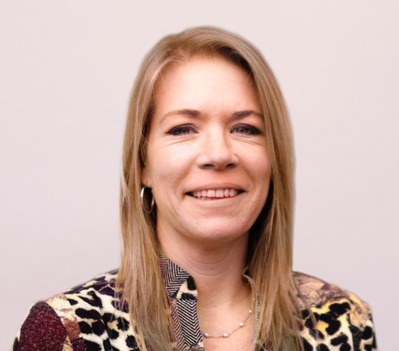 Headshot of woman with shoulder-length blonde hair wearing leopard print jacket against neutral background.