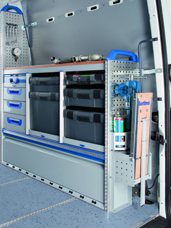Interior of a white trade van showing fitted storage units with blue drawers, shelving compartments and organising systems.