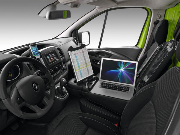 Renault Trafic van interior showing driver's seat with steering wheel, dashboard and laptop mounted on passenger seat…