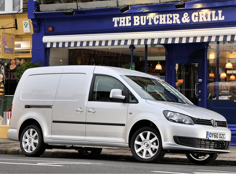 White Volkswagen Caddy van parked outside The Butcher & Grill restaurant storefront.