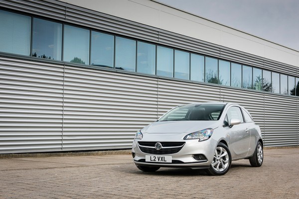 White Vauxhall Corsavan parked in front of corrugated metal warehouse wall.