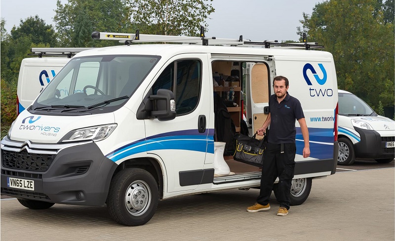 Engineer standing beside white Citroën van with blue Two Housing branding, side door open.