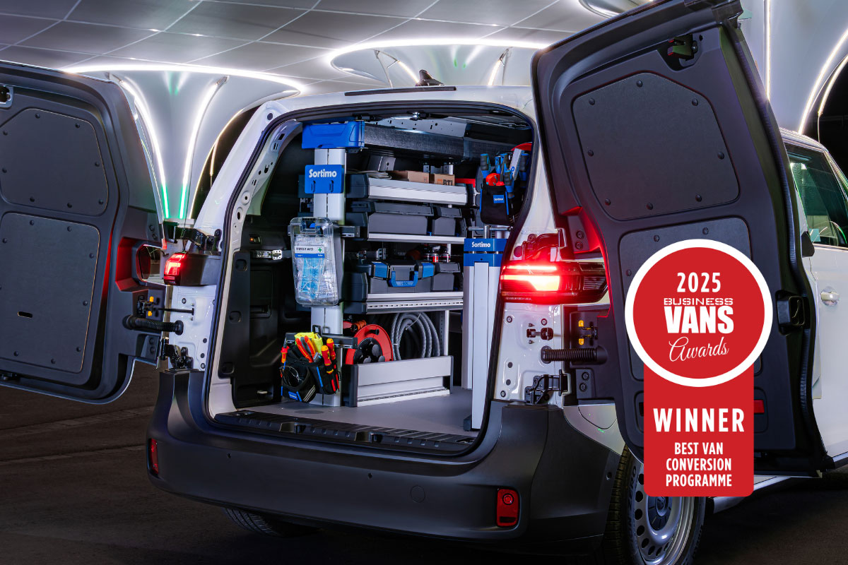 White van with open rear doors displaying blue SR5 racking system and tools, badge showing 2025 Vans Awards Winner for…