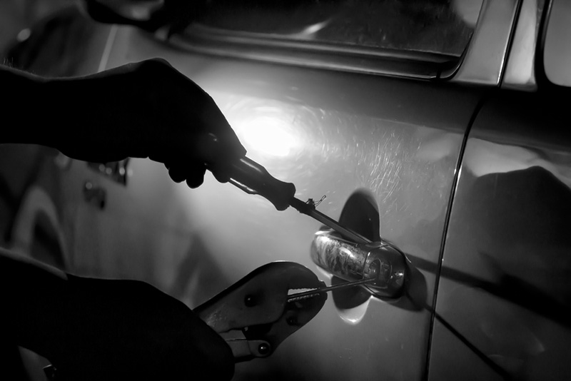 Hand inserting key into van door lock, black and white photograph.