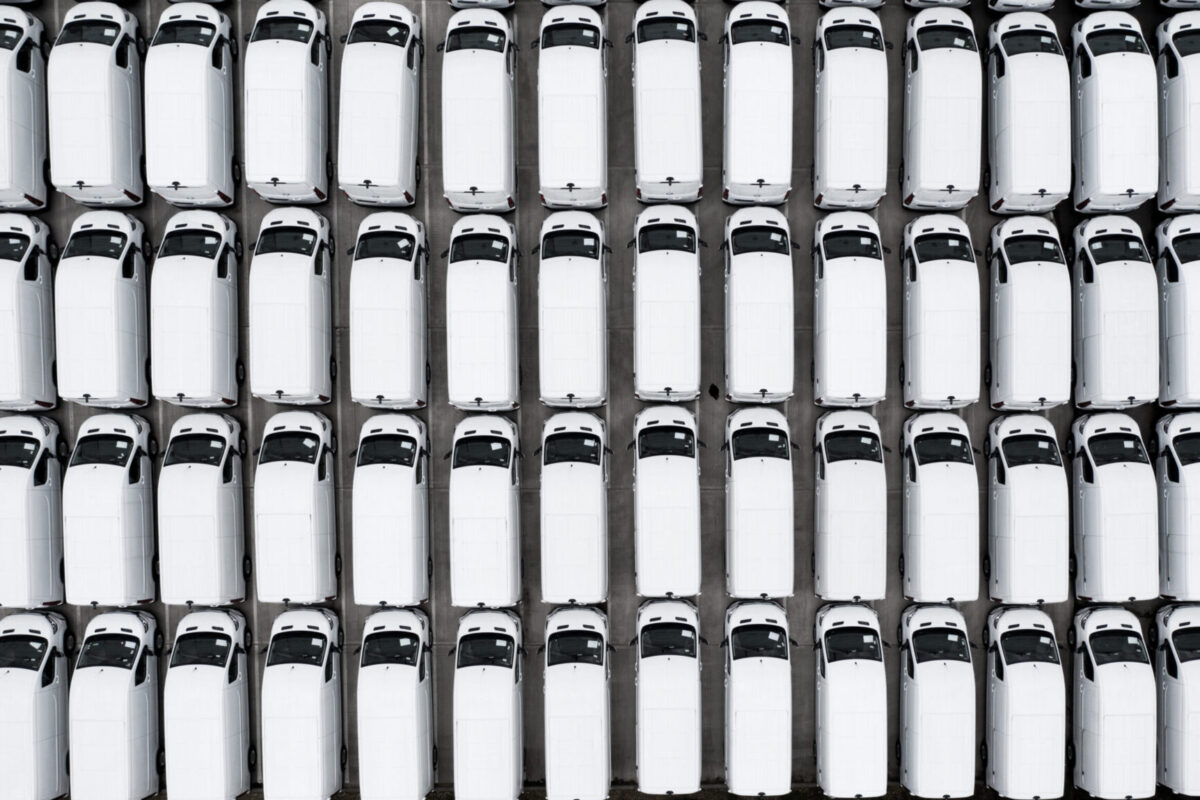 Full frame aerial view of new white vans parked together after manufacturing for import and export