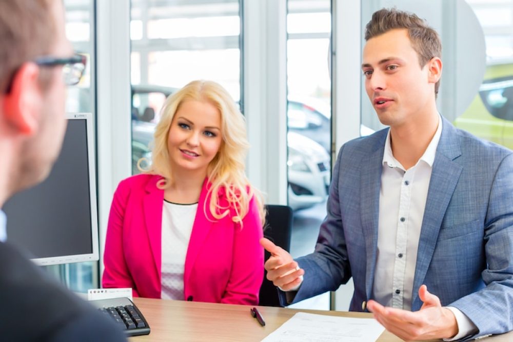 Couple arranging car finance with car dealer
