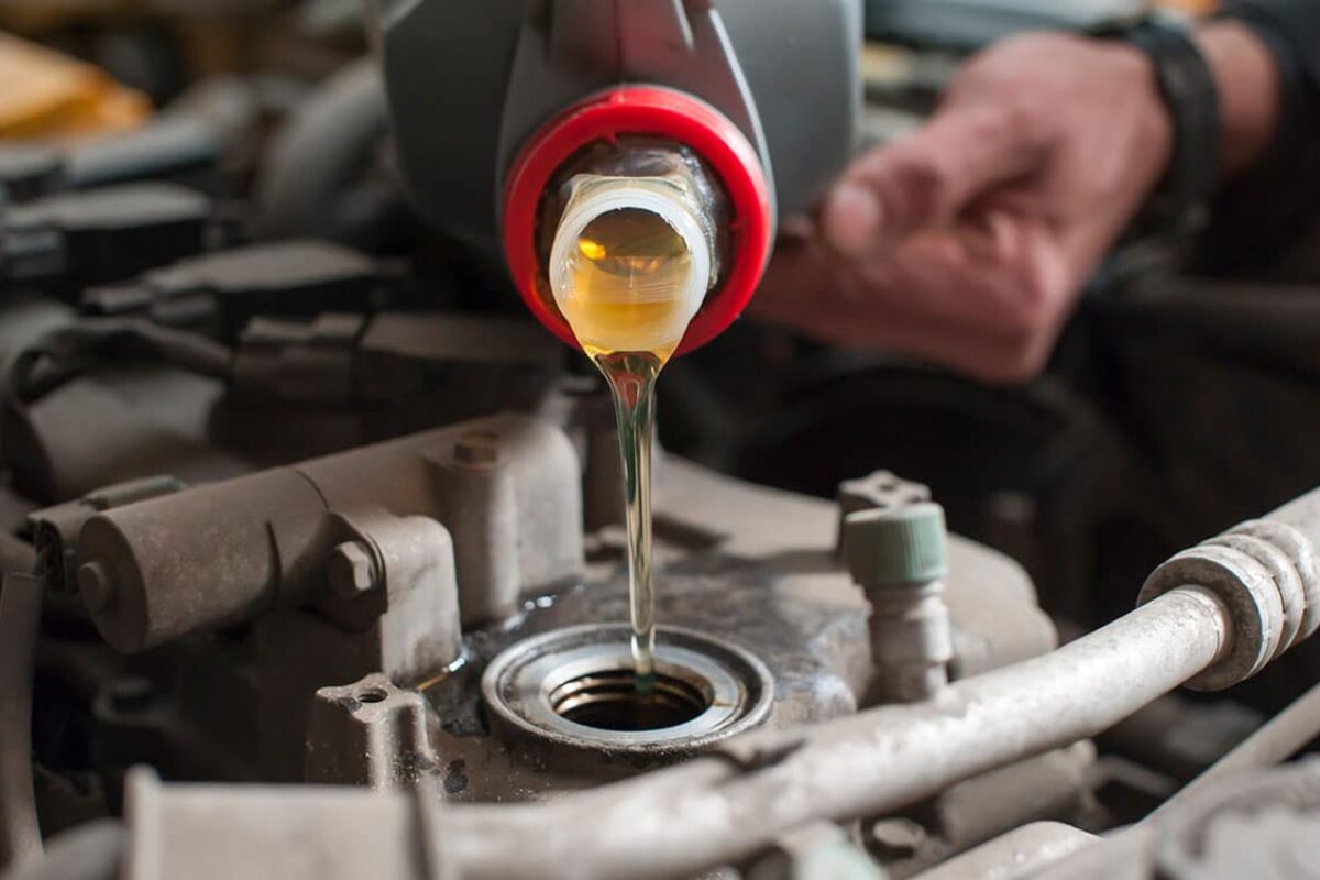 a-man-pours-oil-into-a-car-engine-close-up-2022-11-14-02-16-38-utc