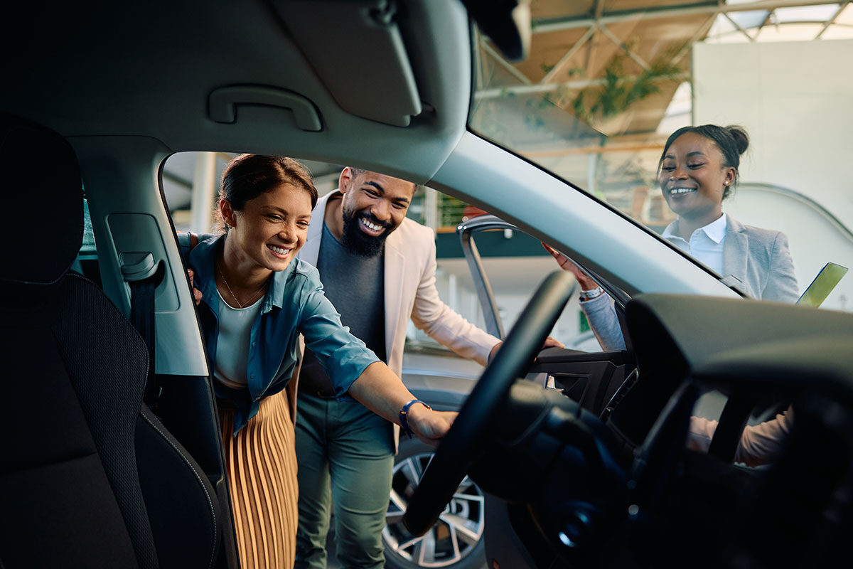 happy multiracial couple looking at new car in sho 2023 11 28 04 23 53 utc