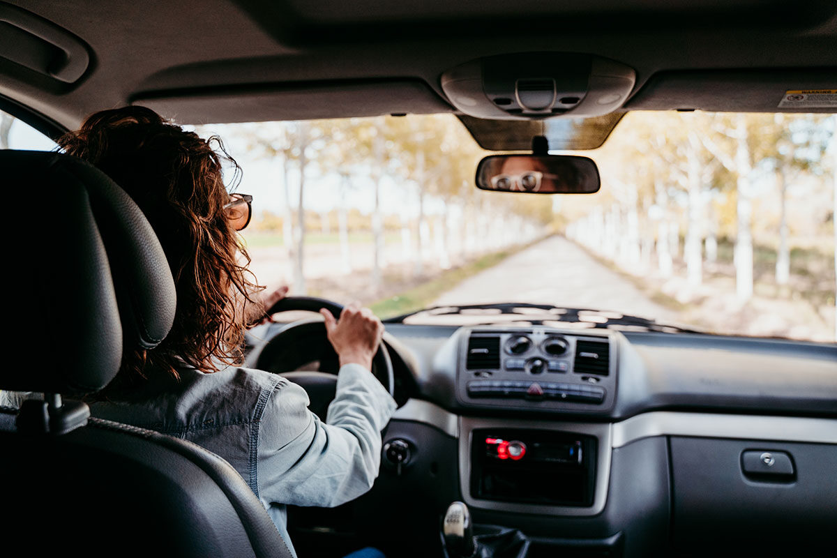 young-beautiful-woman-driving-a-van-by-a-path-of-t-2022-05-09-23-12-02-utc